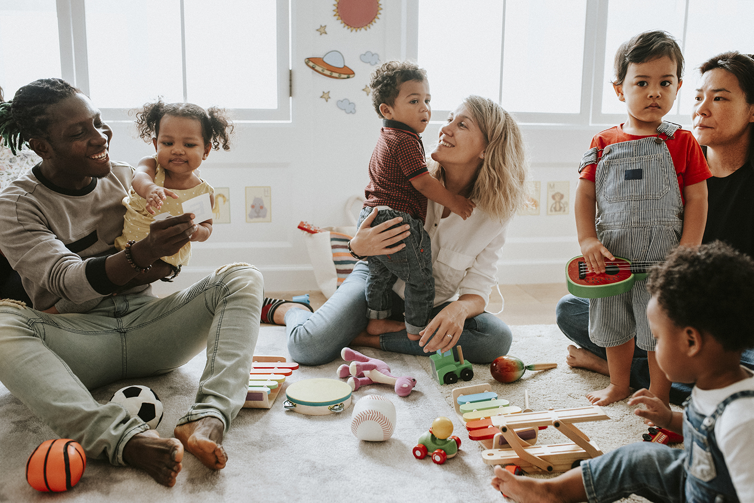 Des enfants qui jouent accompagnés de leurs parents